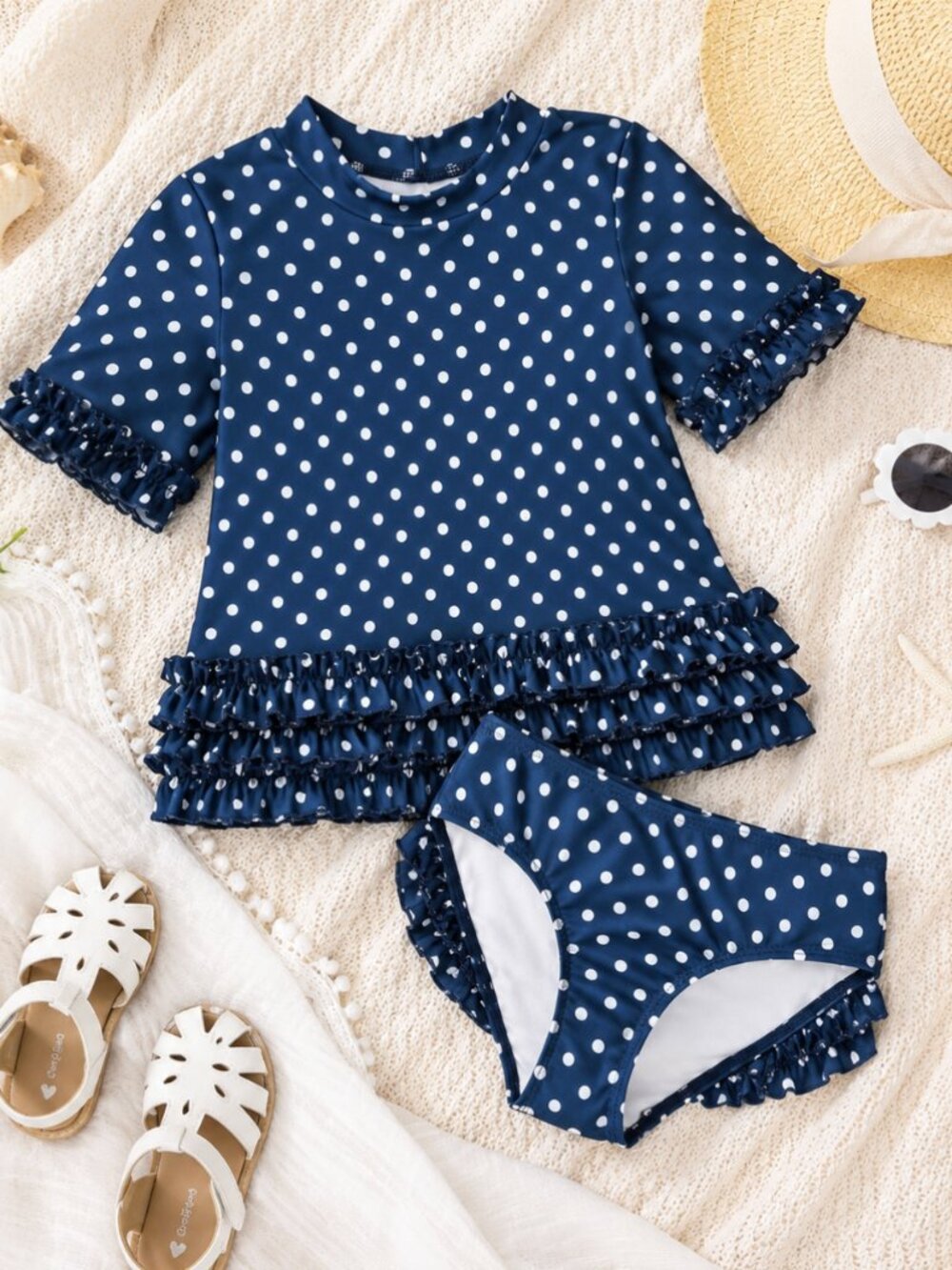 RuffleButts navy blue and white polka dot two-piece swim set in size 4T.